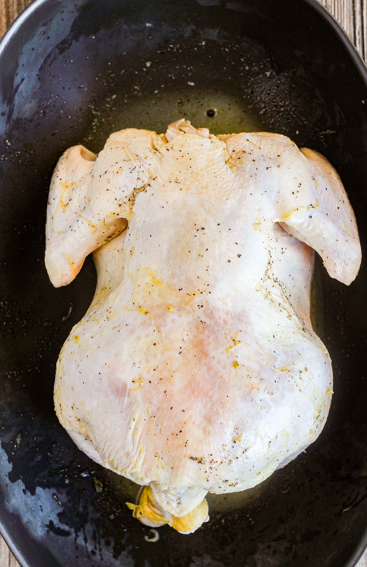 Whole chicken in a roasting pan prior to baking