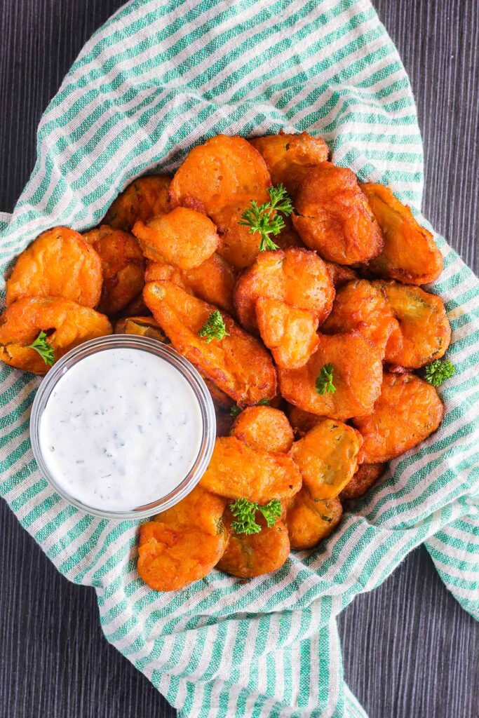 Bowl of buffalo fried pickles with a small bowl of ranch