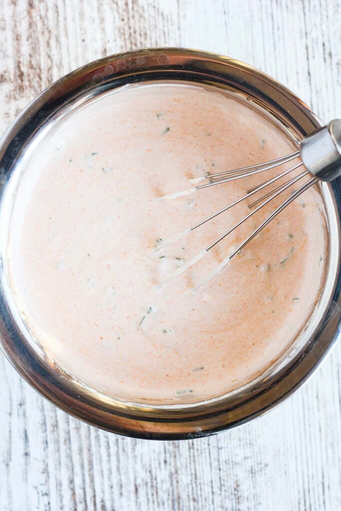 Buffalo ranch sauce in a bowl with a whisk