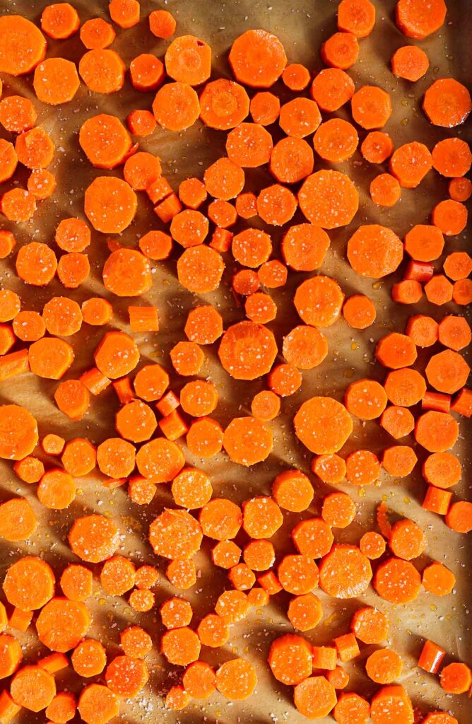 Carrot coins on a baking sheet sprinkled with salt