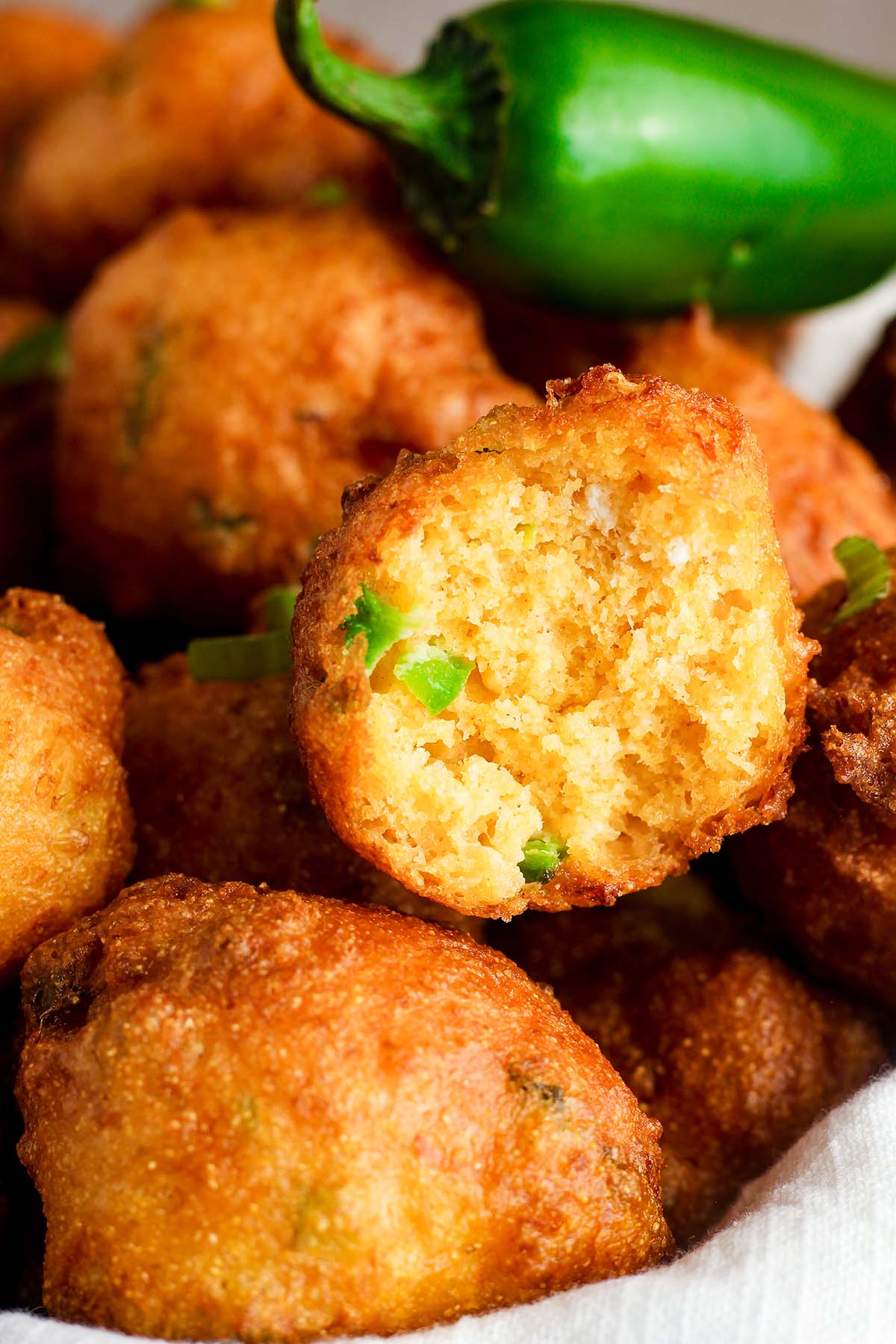 Close up of cheddar hush puppy that has been bitten into