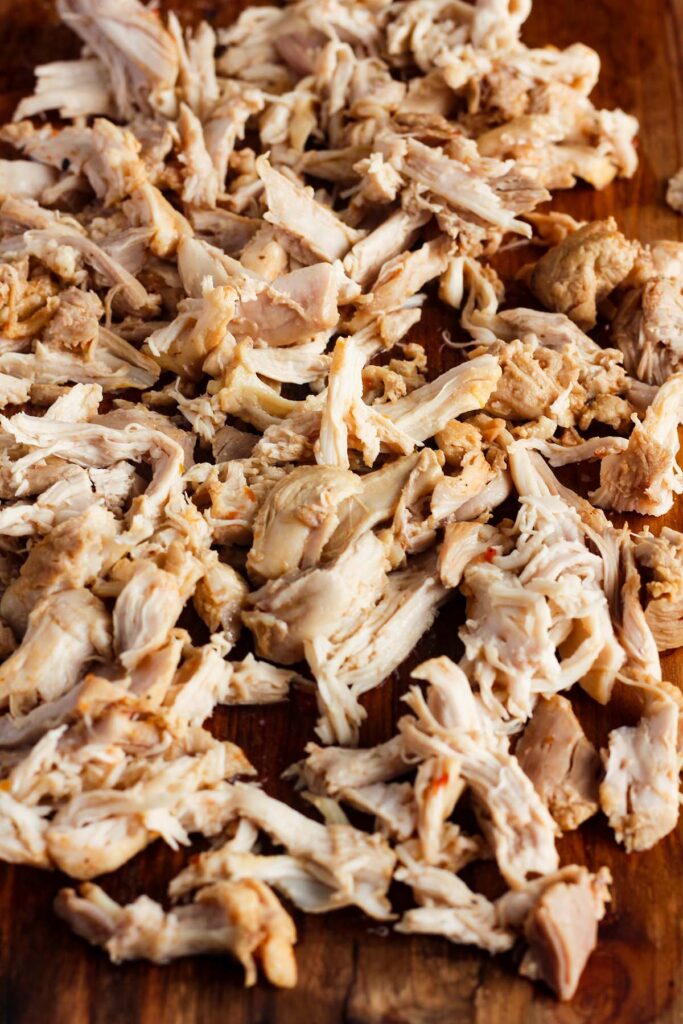 Close up of shredded chicken on a cutting board