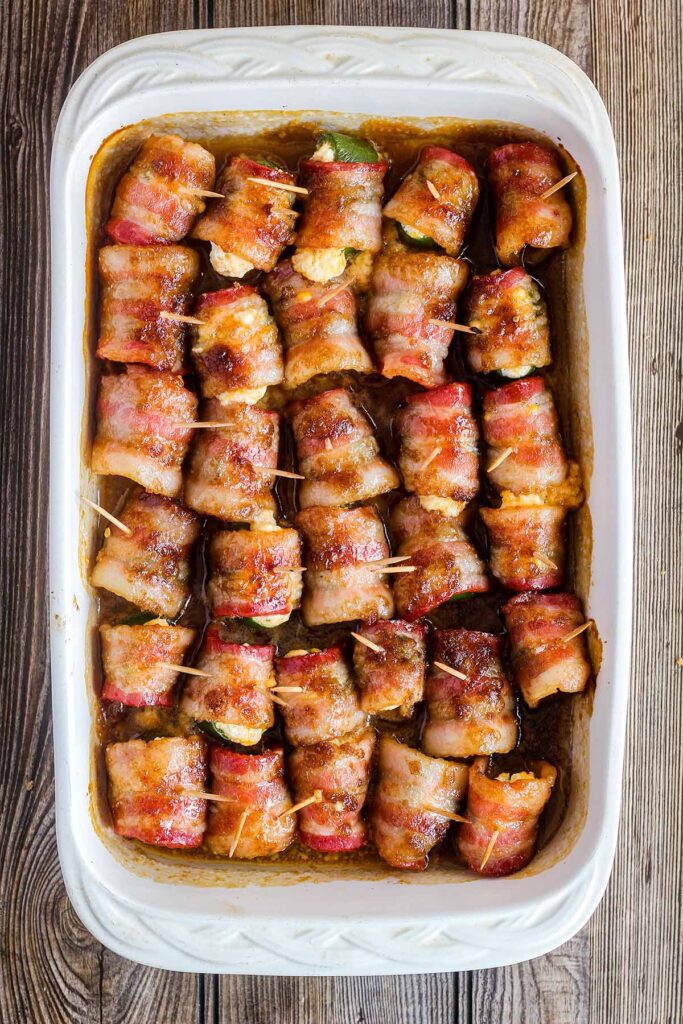 Cooked Bacon Wrapped Jalapeno Poppers with Brown Sugar in a baking dish
