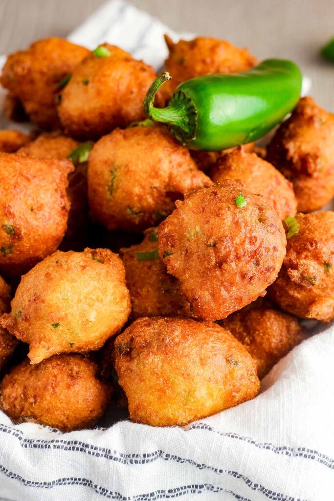 Pile of hush puppies with a jalapeno