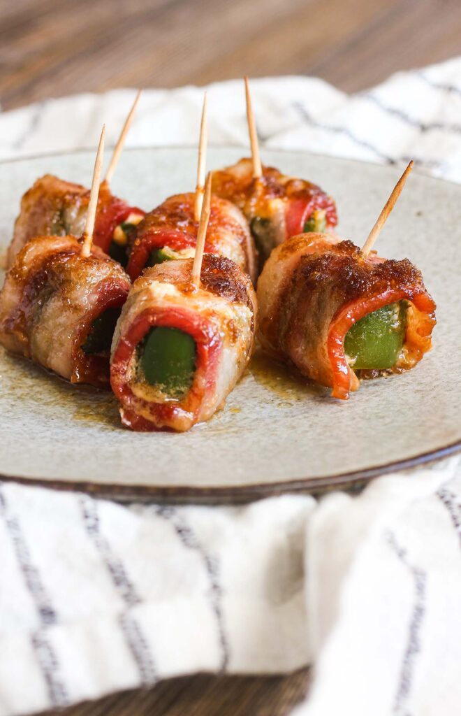 Plate of brown sugar bacon jalapeno poppers atop a white kitchen towel