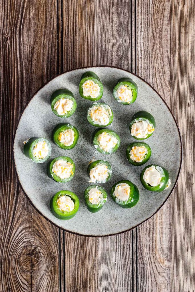 Sliced cream cheese filled jalapenos on a plate