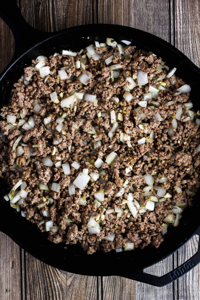 Ground beef with onions and garlic in a skillet.