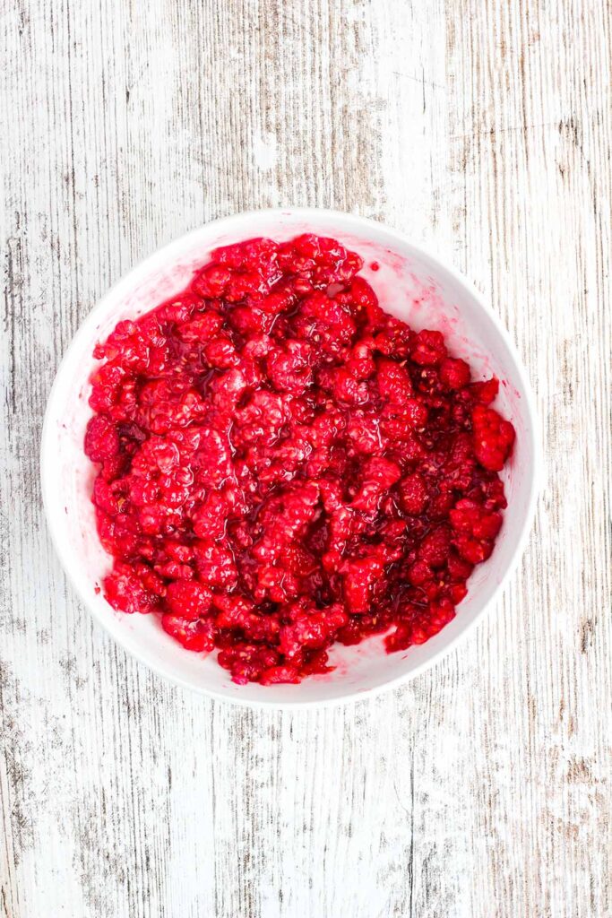 Macerated raspberries in a bowl.