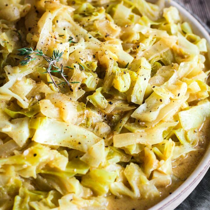Bowl of cabbage garnished with fresh thyme.
