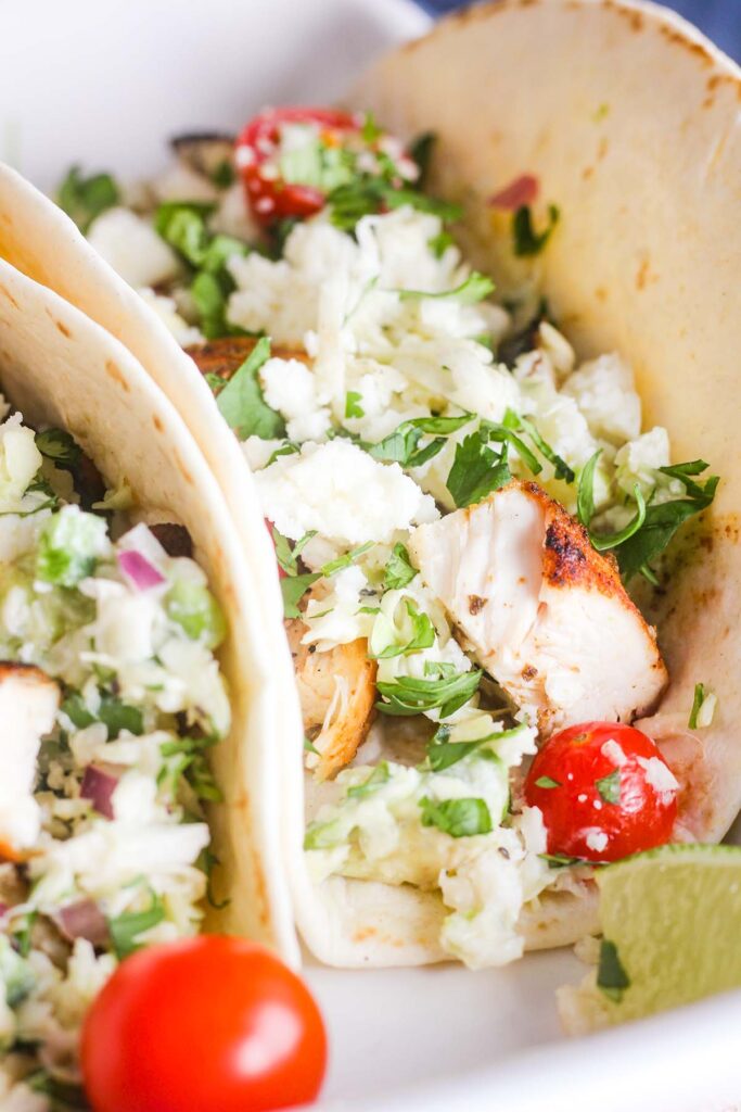 Close-up of blackened chicken tacos with slaw.