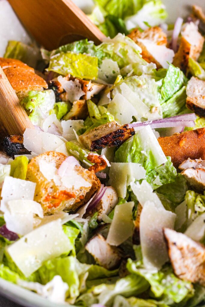 Close up of tossed blackened chicken Caesar salad.