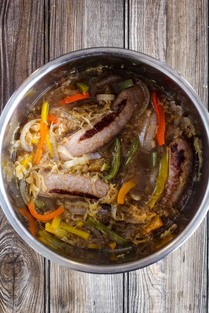 Cooked beer brats in beer with kraut, peppers, and onions in Intstant Pot.