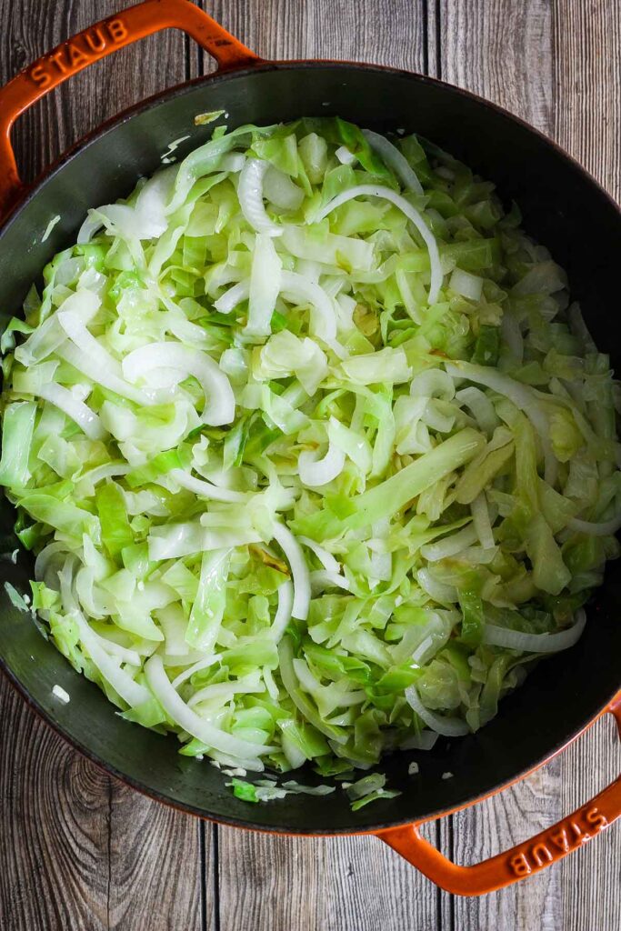 Sautéed cabbage and onions in a Dutch oven.