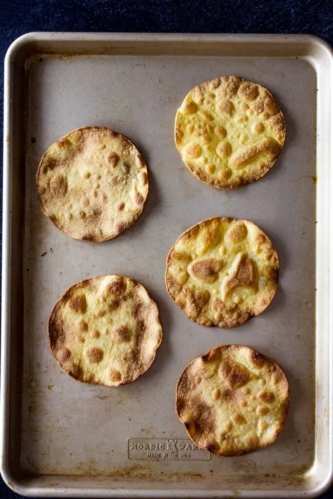 Tostada shells on a baking sheet.