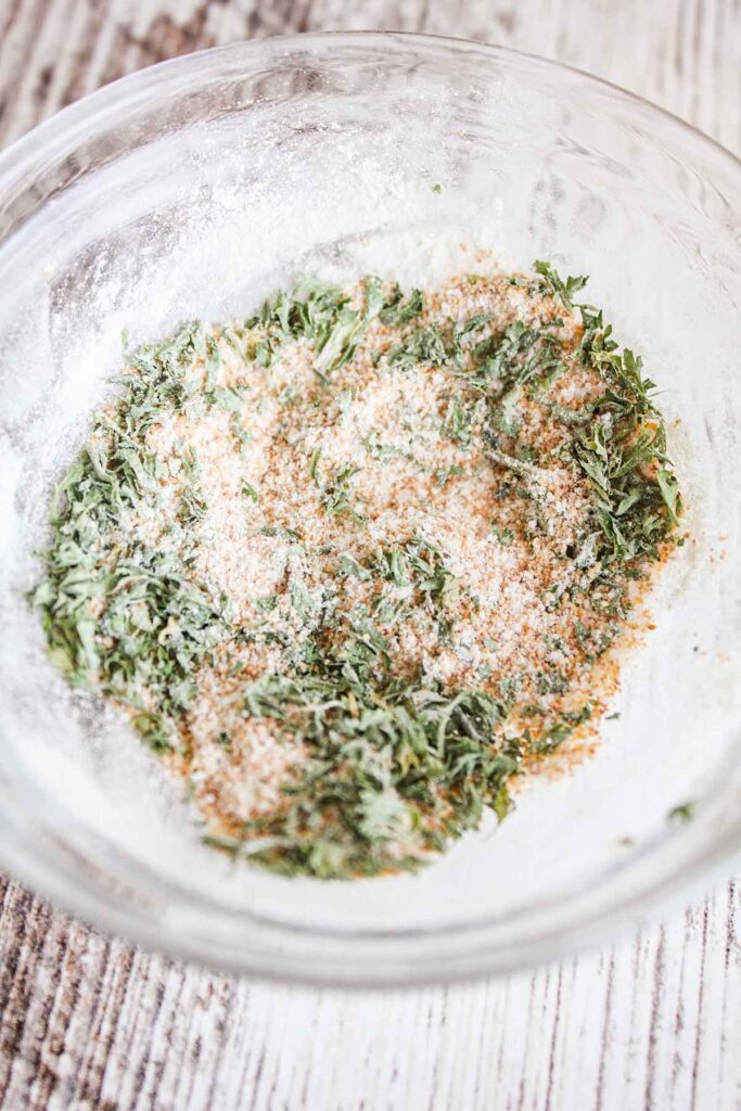 Garlic bread spice mixture in a clear glass bowl.