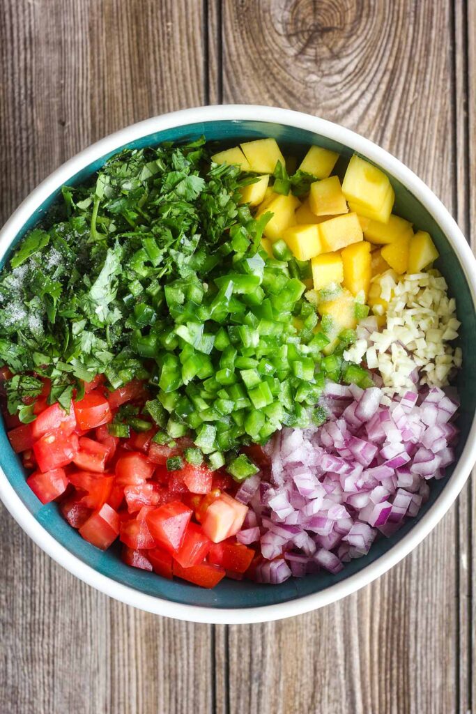 Ingredients for salsa in a bowl, unmixed.