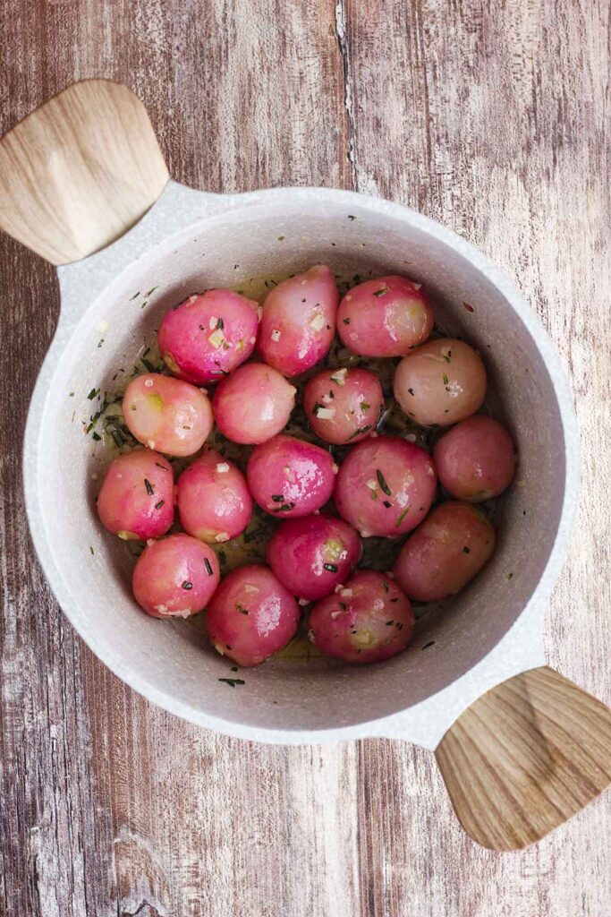 Rosemary butter radishes in a saucepan.