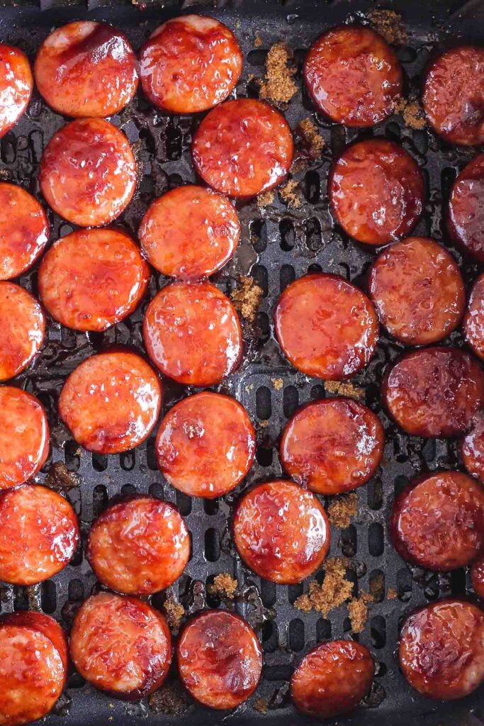 Close up of finished sausage bites in air fryer basket.