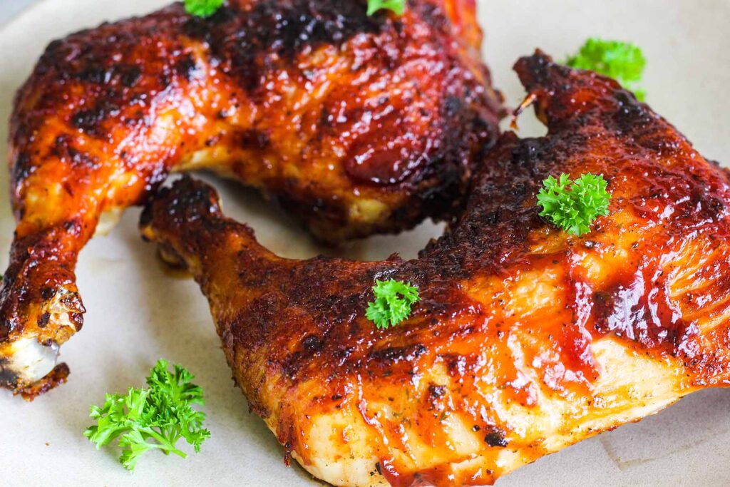 A pair of bbq chicken leg quarters with parsley.