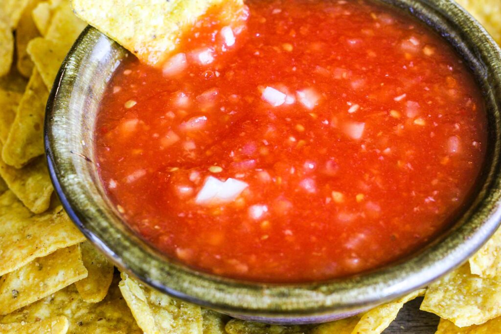 Bowl of simple habanero salsa surrounded by tortilla chips.