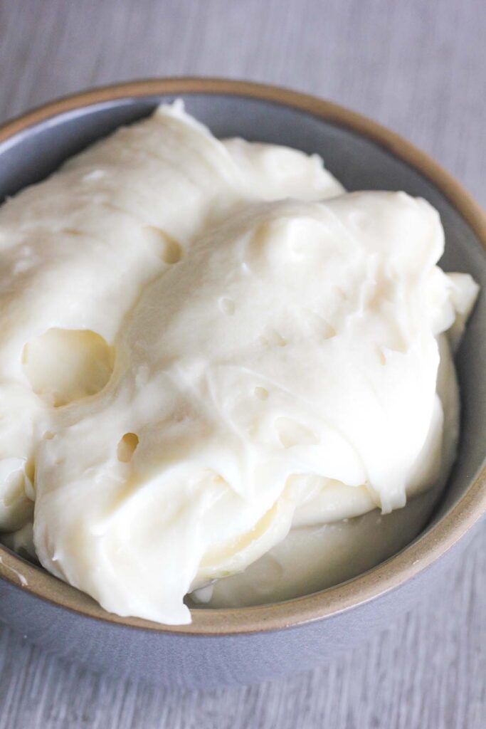 Cream cheese frosting in a grey bowl