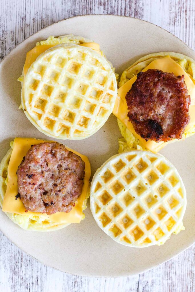 Four sausage waffle sandwiches, two without top waffle.