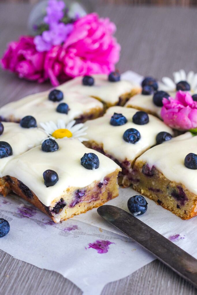 Sliced blondies with blueberries decorated wth flowers.