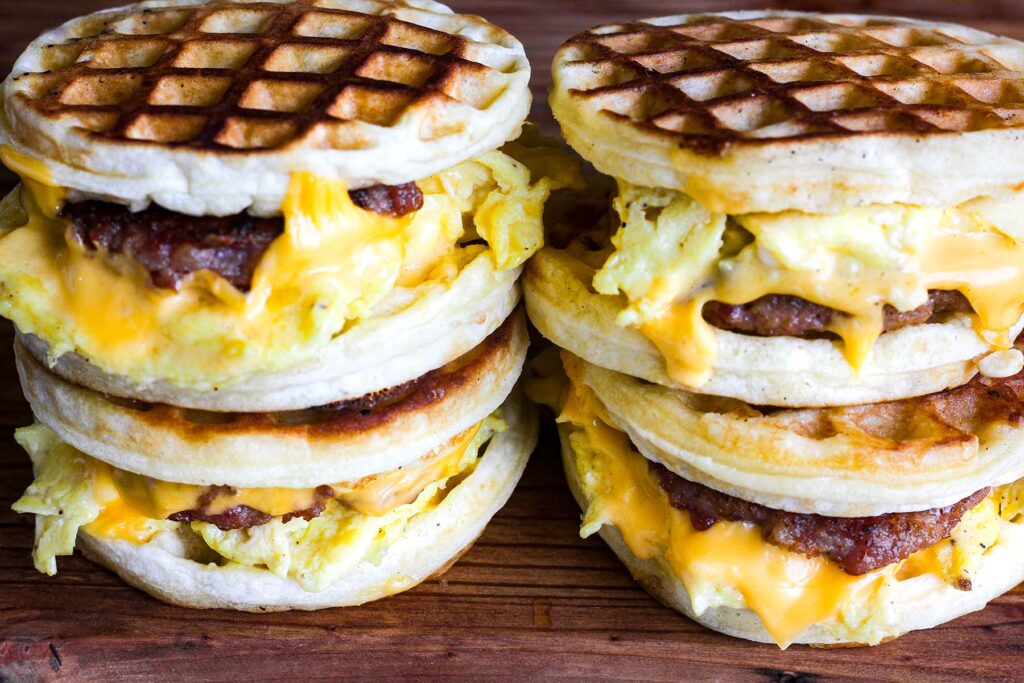 Two stacks of waffle breakfast sandwiches.